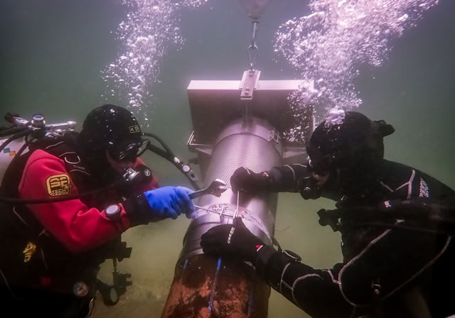 Démontage d'une crépine colonisée par a moule quagga par un plongeur