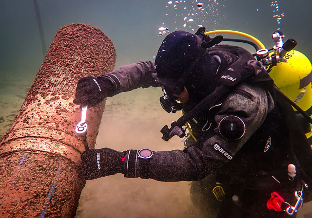 Démontage d'une crépine colonisée par a moule quagga par un plongeur